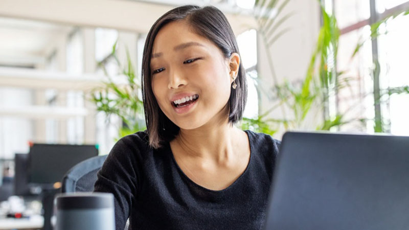 Image of girl and her laptop working and smiling